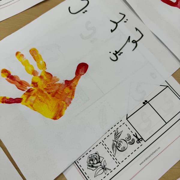 Child handprint artwork with Arabic text